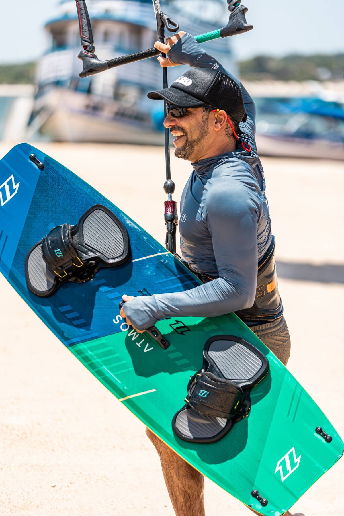 Kitesurfista carregando a prancha na praia